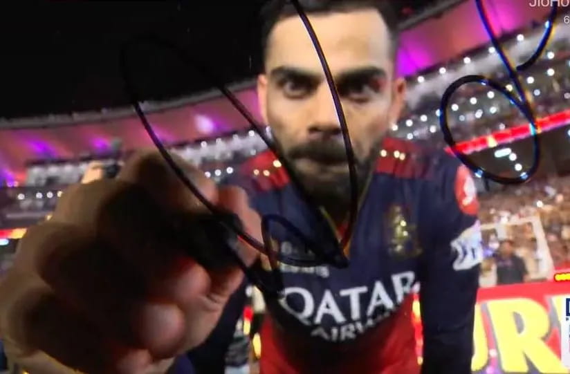 Virat Kohli signs the camera after winning IPL 2025 Final